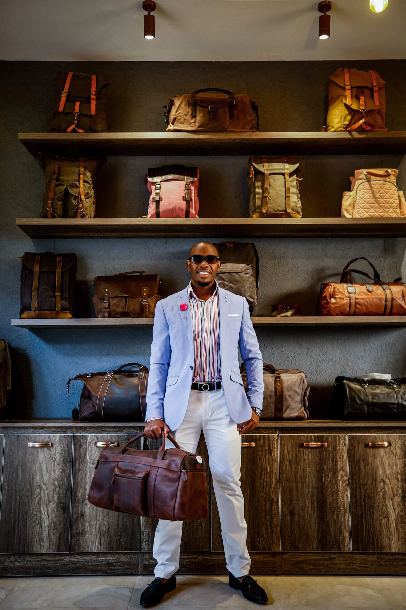 Male model carrying leather travel bag in a shop
