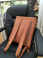 Tan leather backpack on a chair