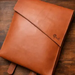 Tan leather backpack on a table