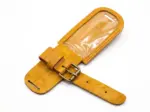 Interior view of an open Qali leather luggage tag made of textured mustard yellow leather, showing a clear plastic slot for an address card, double stitching, and an adjustable brass buckle strap on a white background.